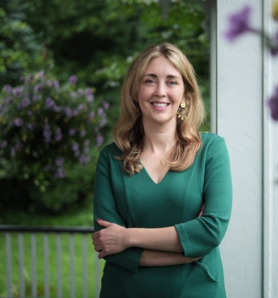 Smiling woman in green dress on porch