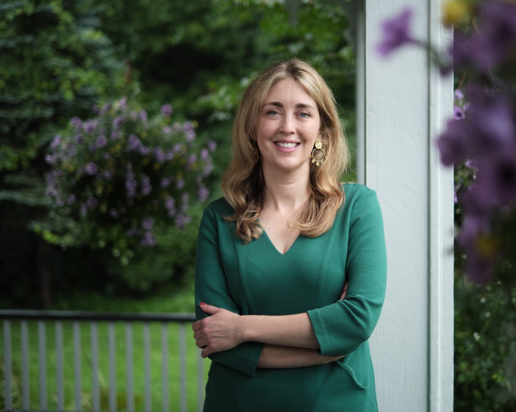 Smiling woman in green dress on porch