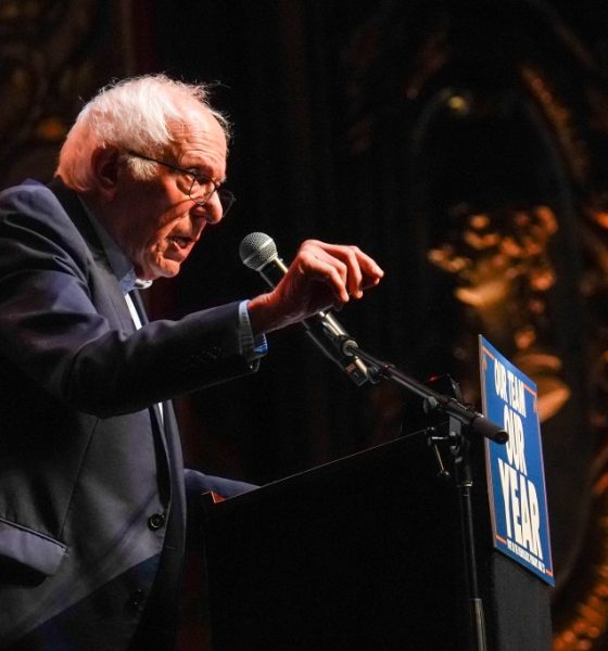 Elderly man speaking at podium during rally