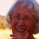 Smiling elderly woman outdoors at sunset