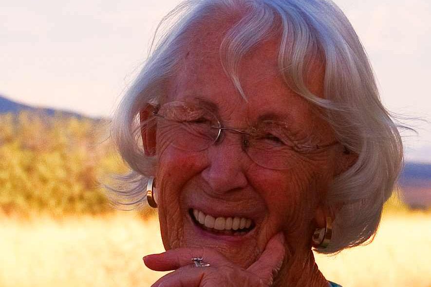 Smiling elderly woman outdoors at sunset