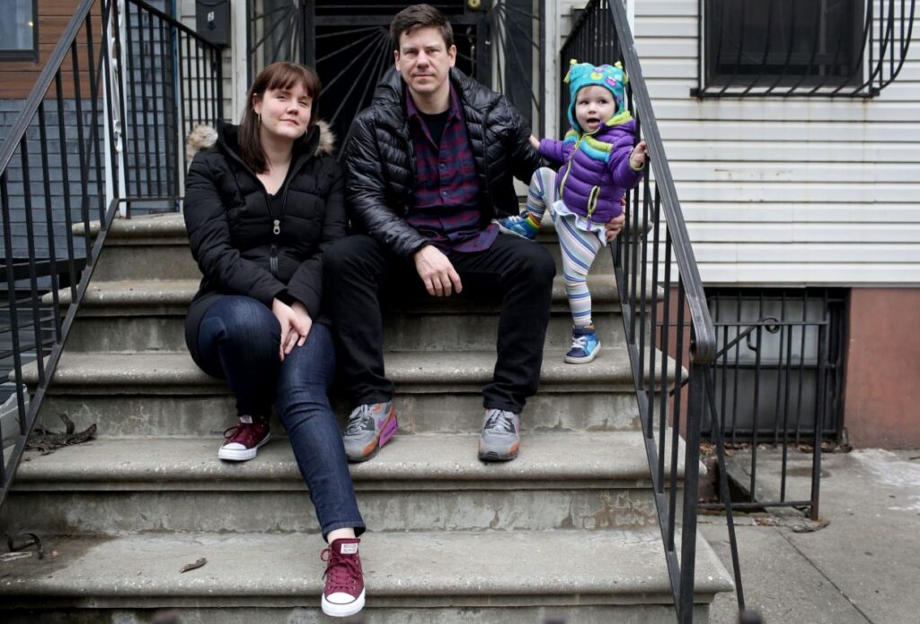 Family sitting on apartment steps with toddler