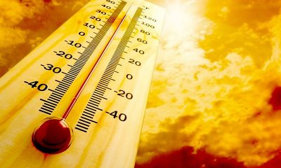 Thermometer showing high temperature against bright sky