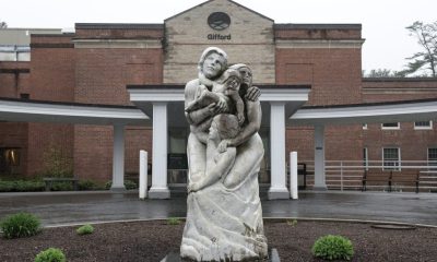 Stone family sculpture outside brick building entrance