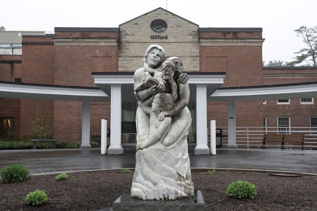 Stone family sculpture outside brick building entrance