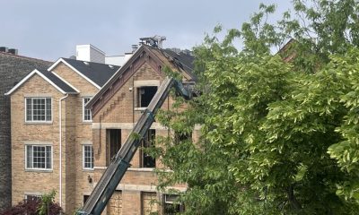 Worker repairing roof of brick house