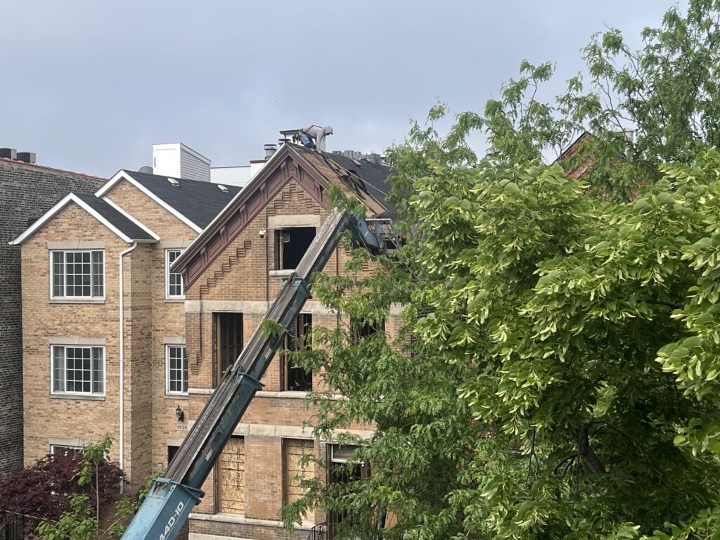 Worker repairing roof of brick house