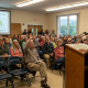 Community meeting with speaker addressing seated audience