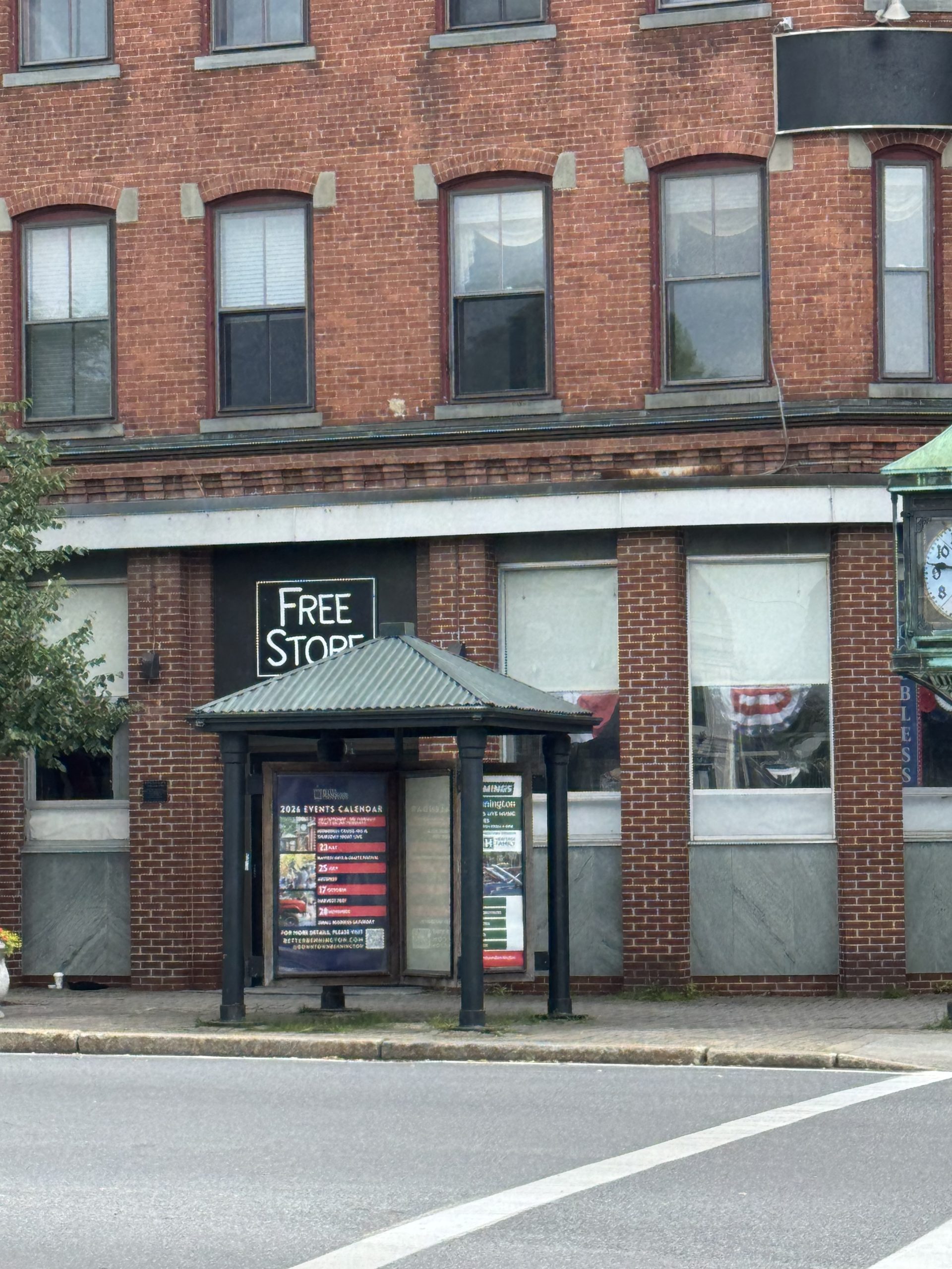 Brick building with bus shelter and Free Store sign