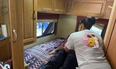 Woman comforting person lying on RV bed