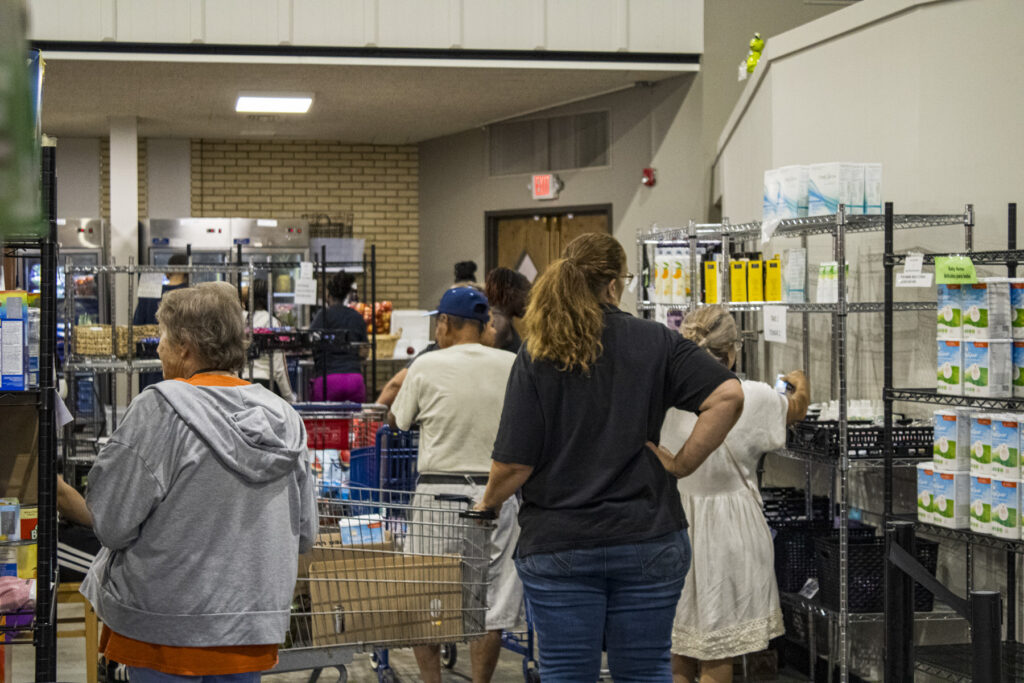 People shopping at indoor food pantry shelves