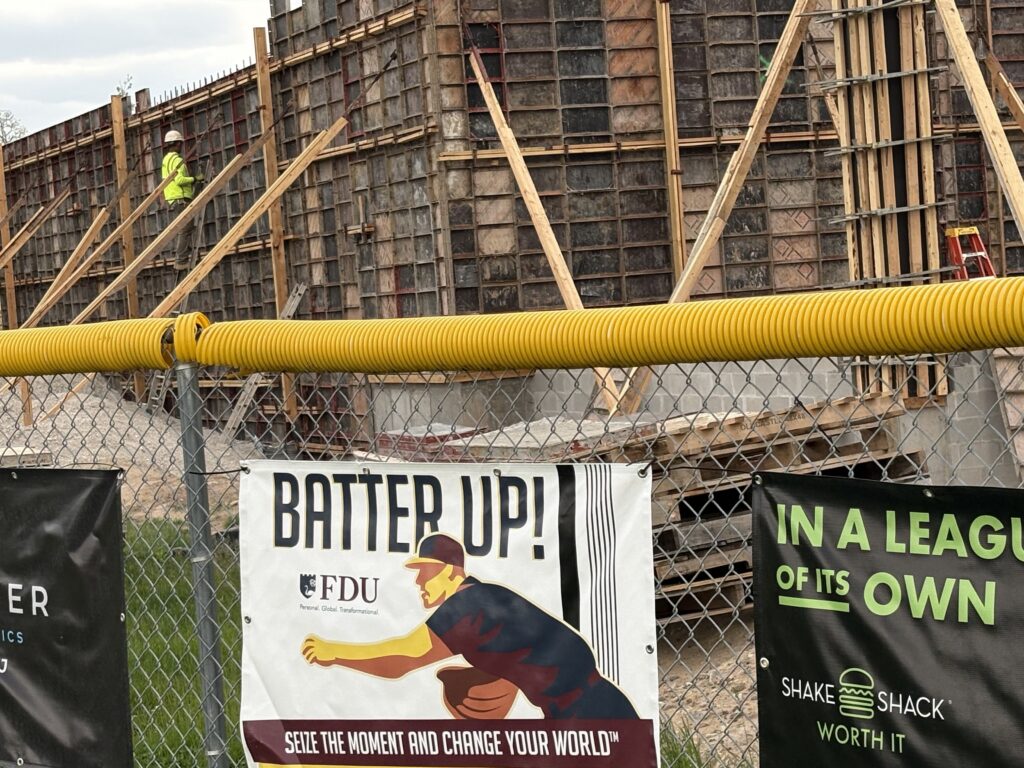 Construction site behind fence with baseball banners