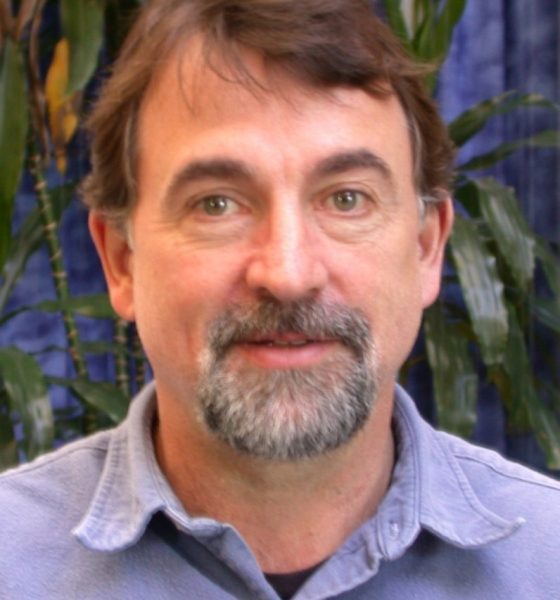 Man with beard posing indoors near plants