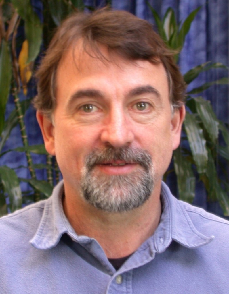 Man with beard posing indoors near plants