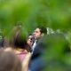 Man speaking into microphone at outdoor gathering