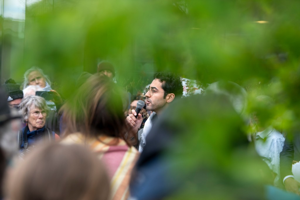 Man speaking into microphone at outdoor gathering