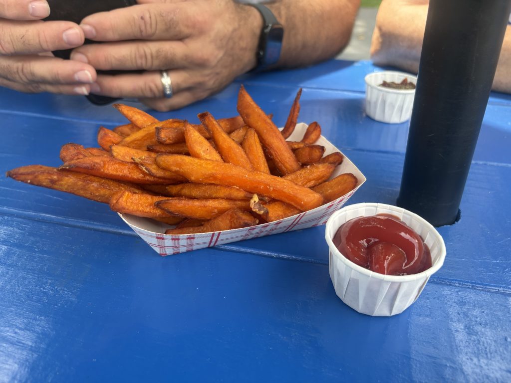 Sweet potato fries with ketchup on blue table