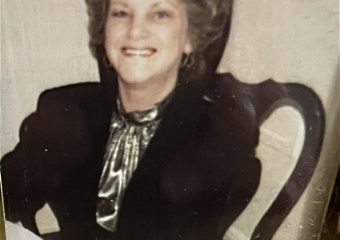 Smiling woman seated at table in vintage photo