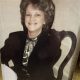 Smiling woman seated at table in vintage photo