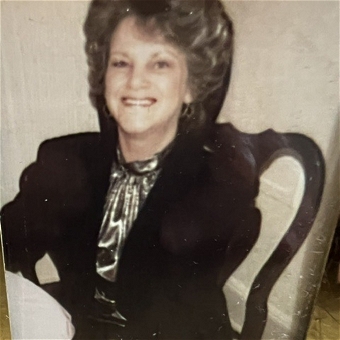 Smiling woman seated at table in vintage photo