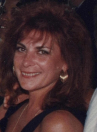 Smiling woman with auburn hair and gold earrings
