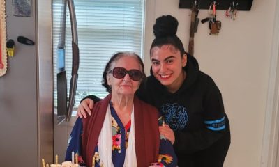 Elderly woman with birthday cake and younger companion