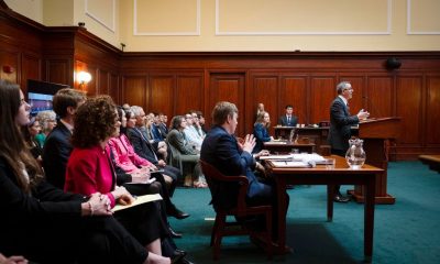 Lawyer speaking in wood-paneled courtroom hearing