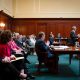 Lawyer speaking in wood-paneled courtroom hearing