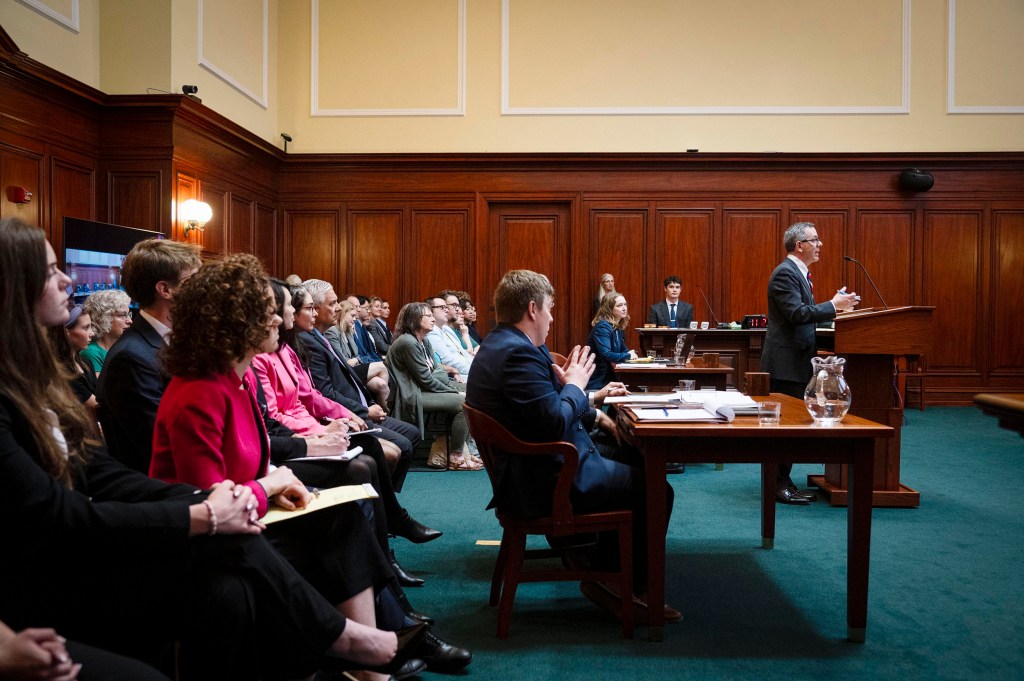 Lawyer speaking in wood-paneled courtroom hearing