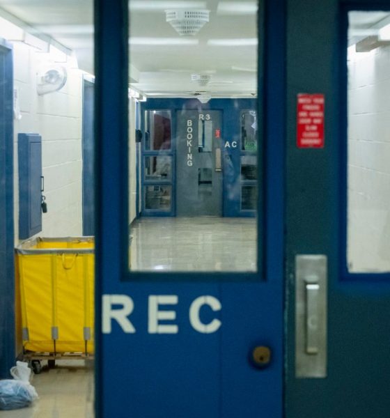 Jail corridor with blue doors and yellow cart
