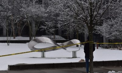 Snow-covered sculpture behind yellow caution tape