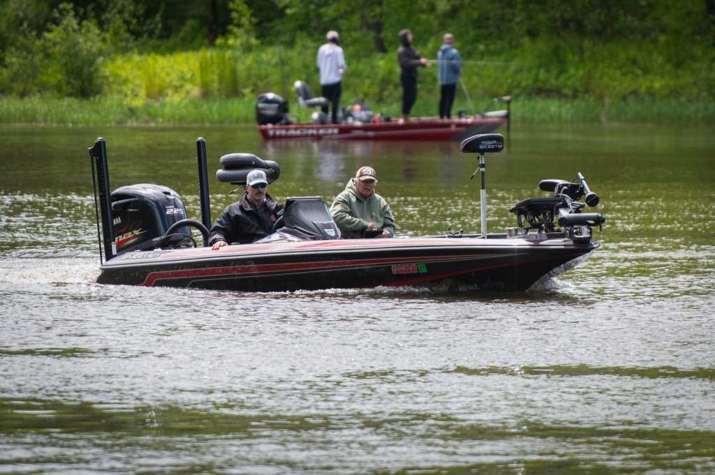 Two men fishing from bass boat on lake