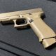 Tan Glock 19X handgun on black surface