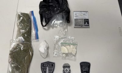 Seized drugs, scale, and police badges on table