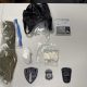 Seized drugs, scale, and police badges on table