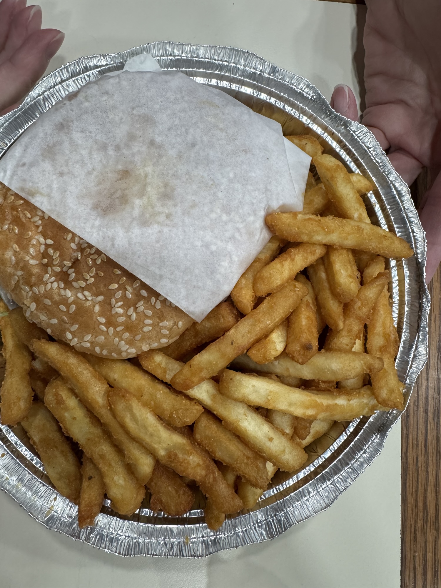 Burger and French fries in foil tray