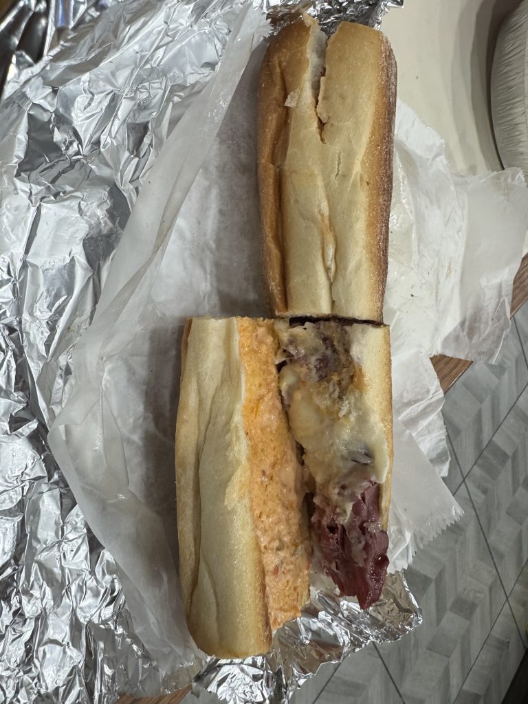 Cheesy roast beef sub on foil wrapper