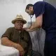 Doctor examining elderly man with stethoscope