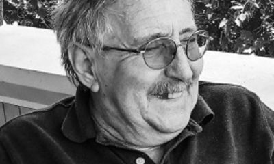 Older man with glasses smiling outdoors