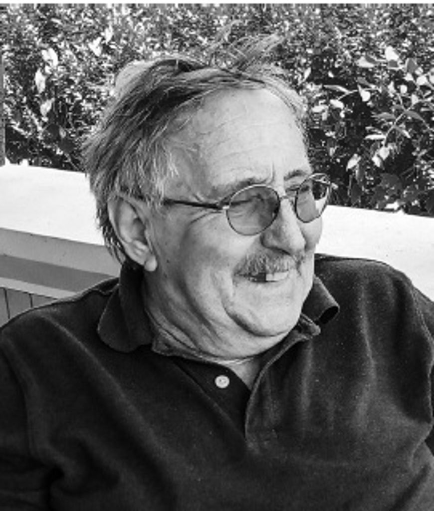 Older man with glasses smiling outdoors