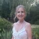 Smiling woman in white dress in garden