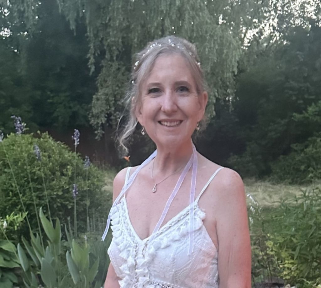 Smiling woman in white dress in garden