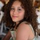 Smiling girl with curly hair indoors