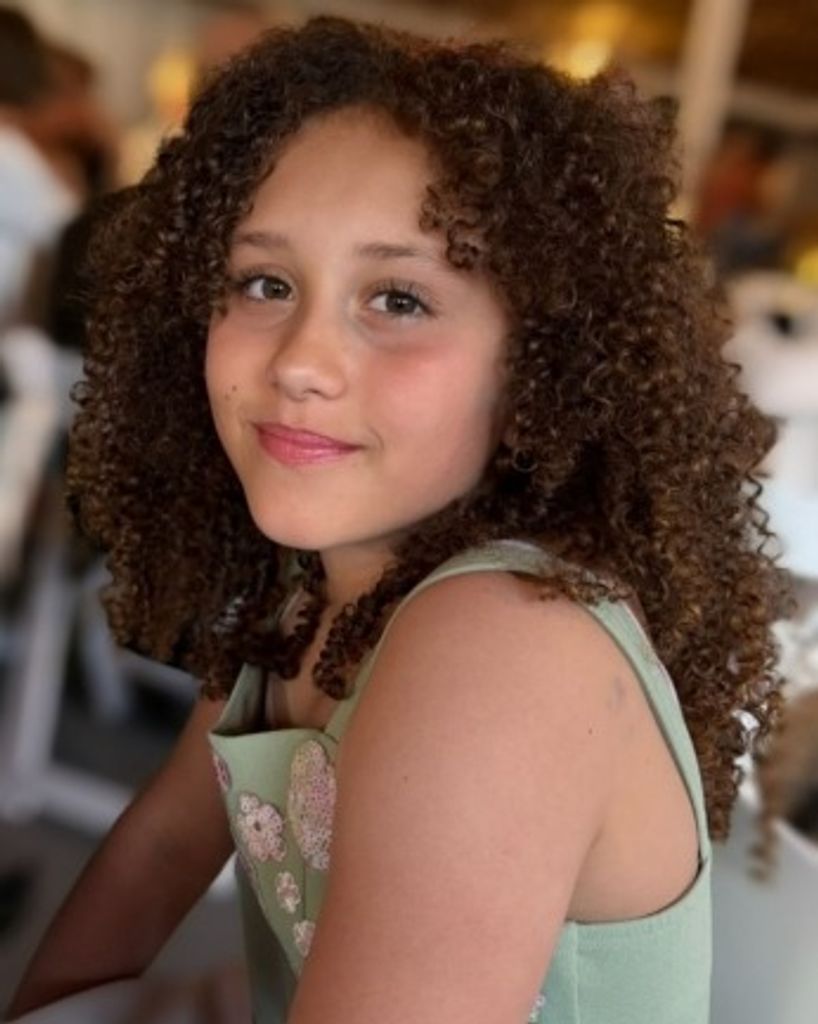 Smiling girl with curly hair indoors
