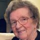 Smiling elderly woman wearing glasses indoors