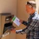 Man placing envelope into ballot drop box