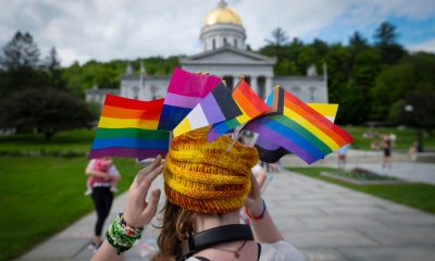 Person wearing Pride flags before capitol building