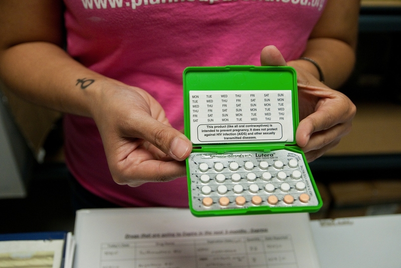 Person holding open birth control pill pack