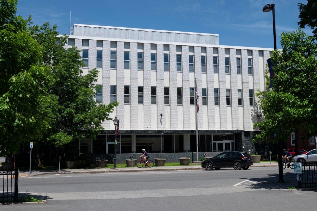 White brick office building along tree-lined street