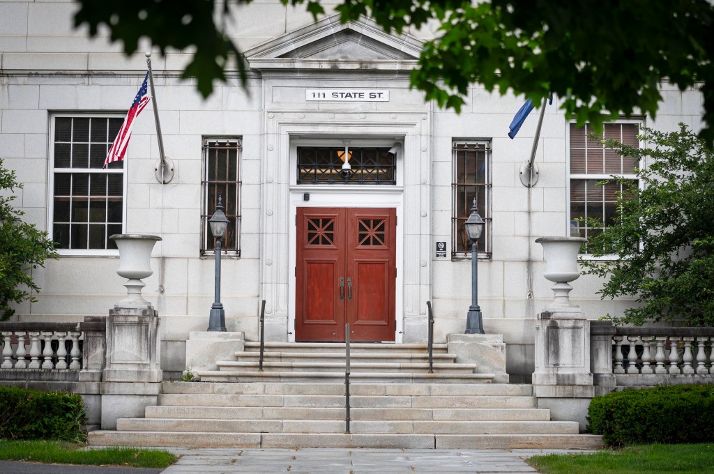 Entrance of 111 State Street building with flags